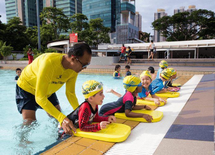 a swimming coach for kids giving individualised feedback