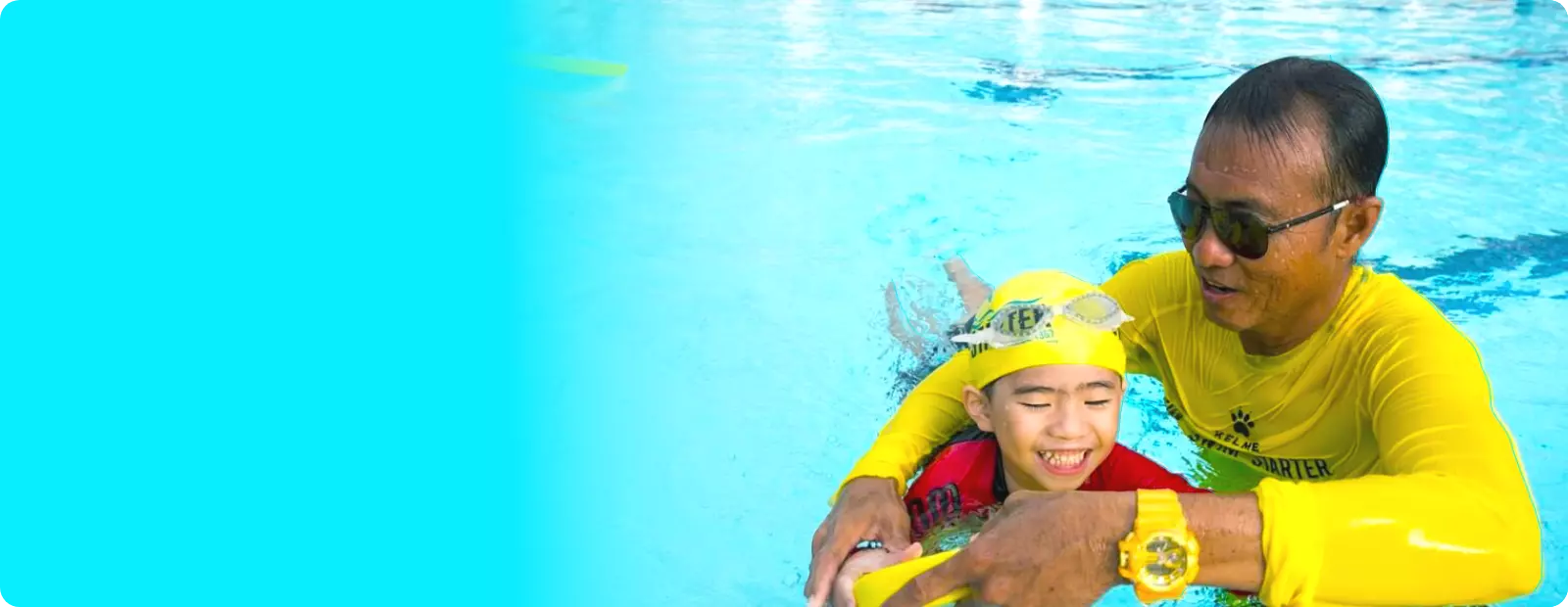 Singapore Swimming Coach is coaching a child to learn to swim in the swimming pool with a yellow swimming board during swimming lessons.
